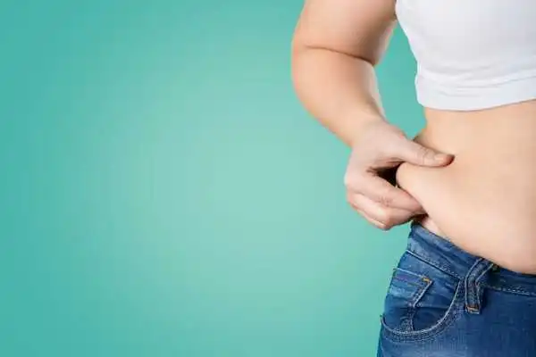 Image of woman pinching her love handles to show weight gain Leatherhead