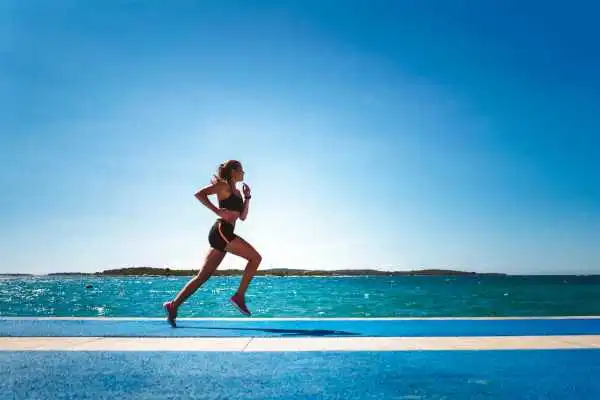 Woman running showing strong leg muscle Leatherhead